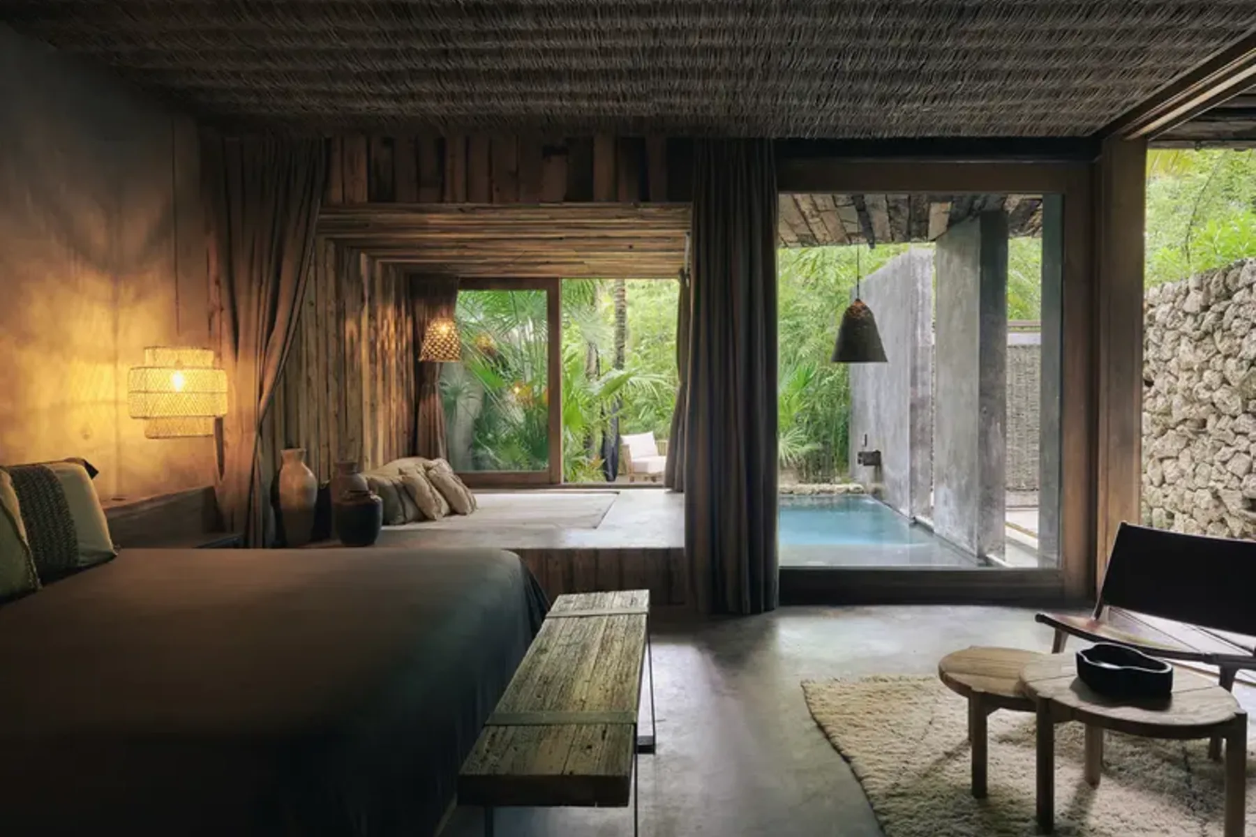 Interior suite with private pool, bed, coffee table, and harmonious furniture. Jungle ambiance at Be Tulum.