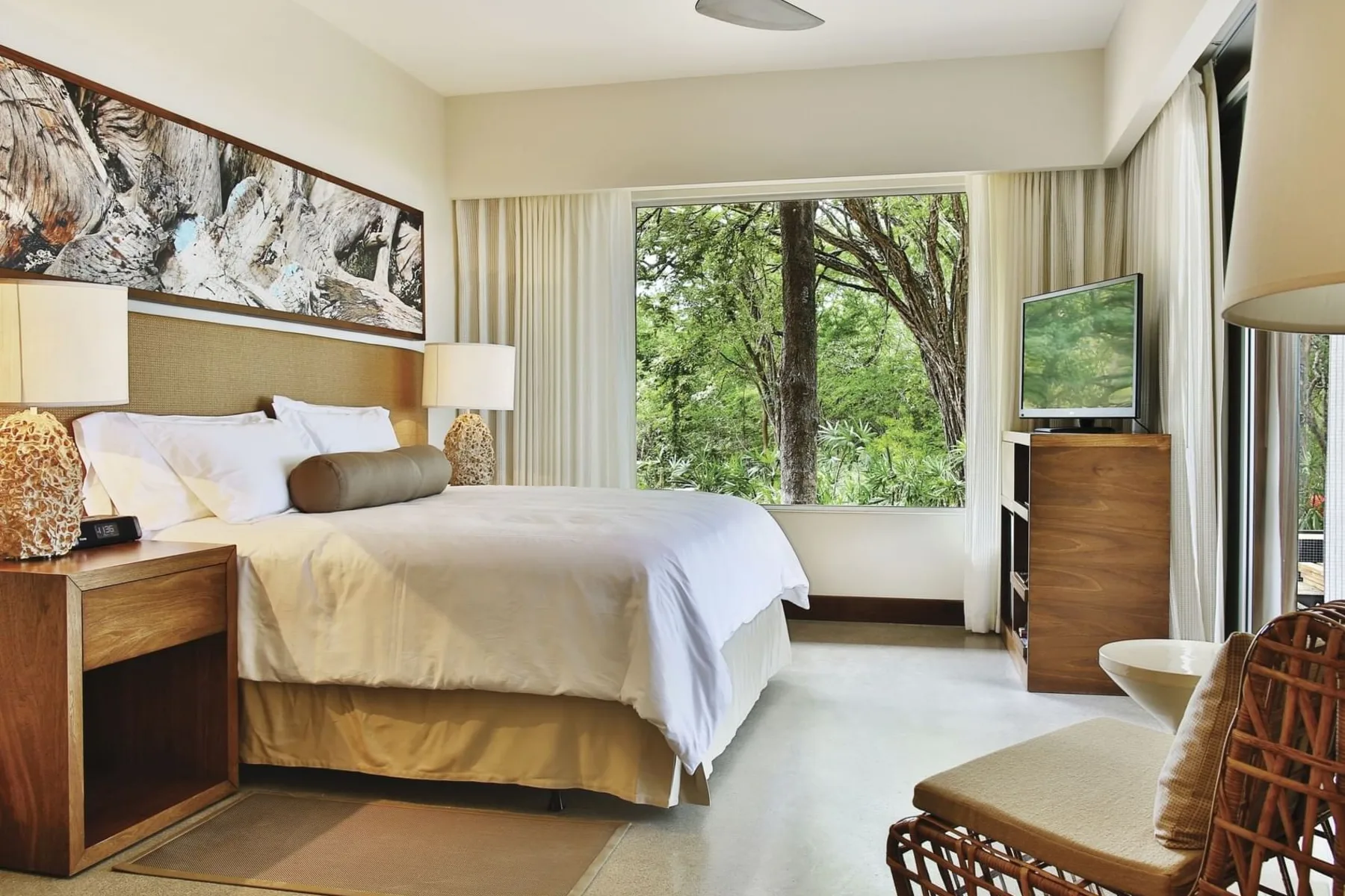 Bark with bed, art and garden view through the window at El Mangroove Hotel