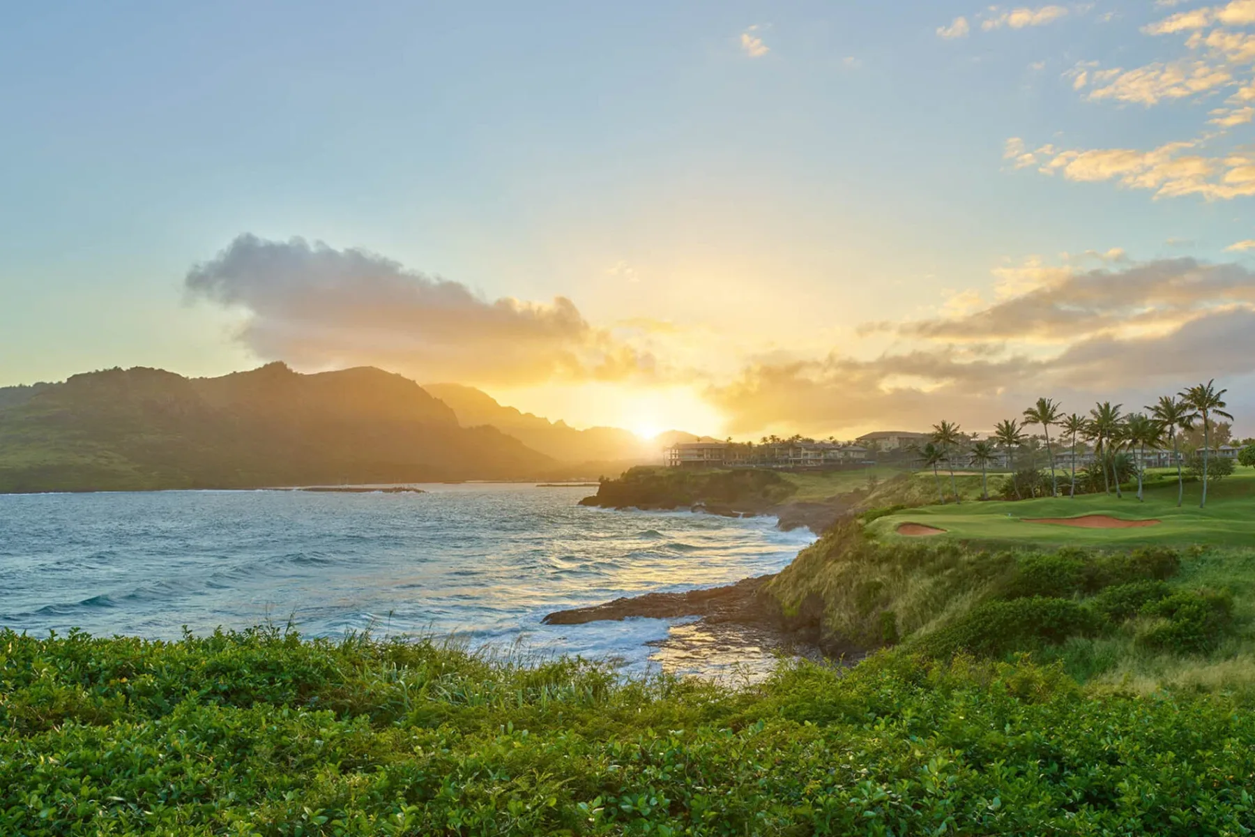 Sunsetting behind Timbers Kauai and the Hāʻupu Mountains on Kauai within the Hokuala Hawaii resort, as viewed from the 14th tee of the Ocean Course at Hokuala