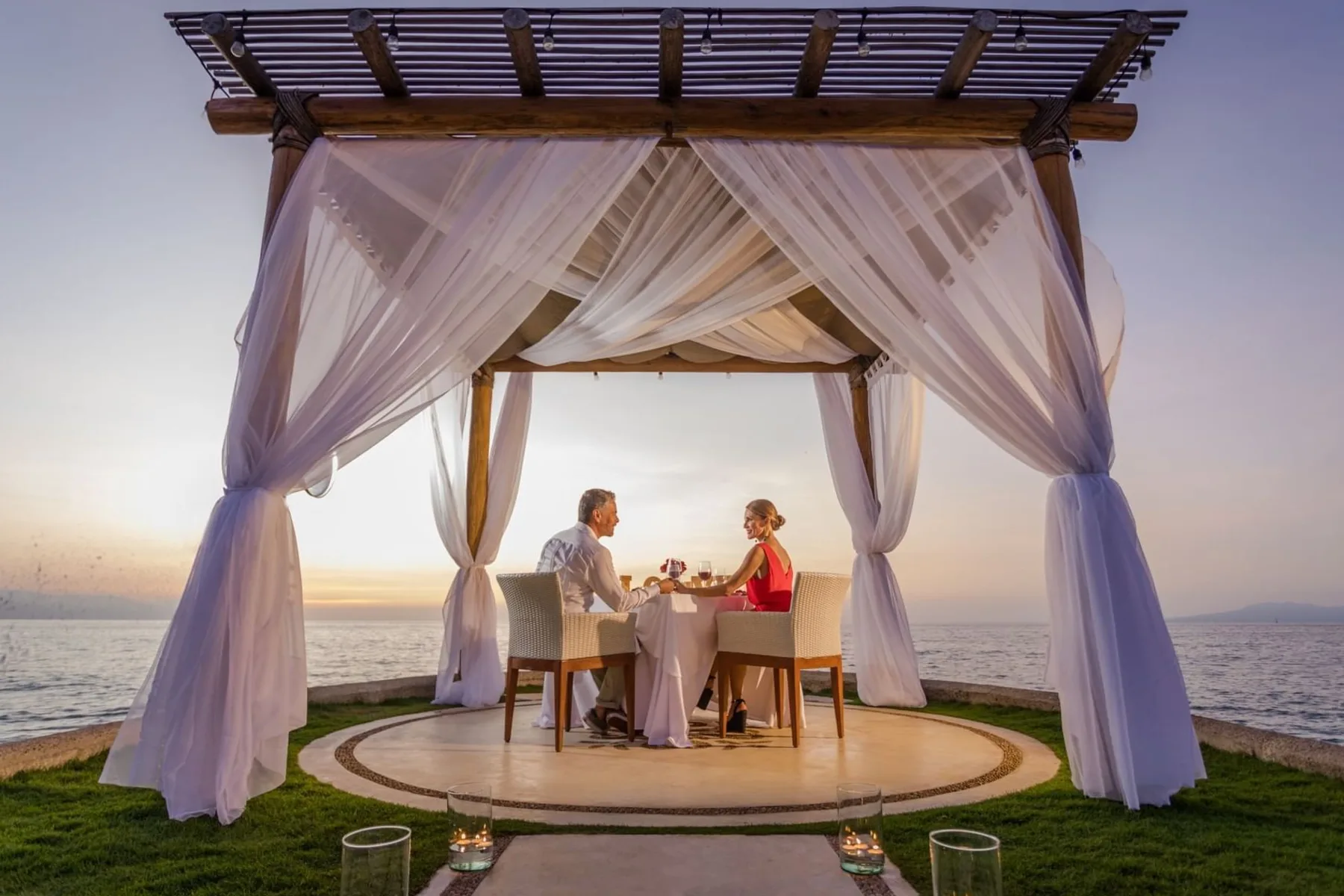 Couple dining under a pergola by the sea at Villa Premiere Boutique Hotel & Romantic Getaway